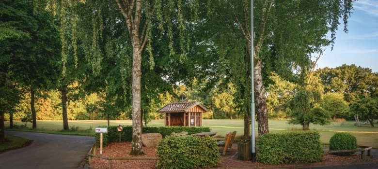 Roter Platz Behningen Der "rote Platz" in Behningen. Kleiner Aufenthaltsort mit einem Tisch und Bänken. Im Hintergrund ist eine Bushaltestelle mit Wetterschutzhütte zu sehen.